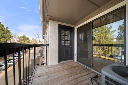 A balcony with a black door and a black railing.