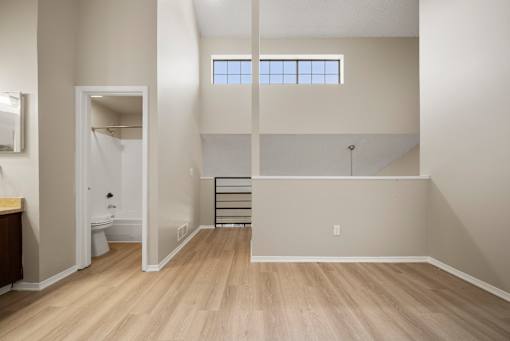 A bathroom with a toilet, sink, and a window.