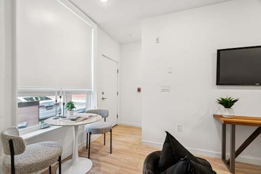 A room with a white wall and a black television.