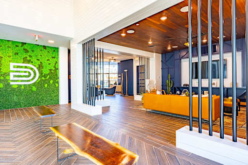 A modern office lobby with a green wall and a wooden floor.