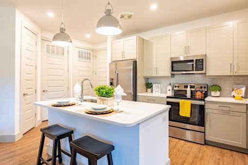A kitchen with a white island and stools.