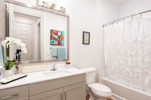 A white bathroom with a toilet, sink, and shower.