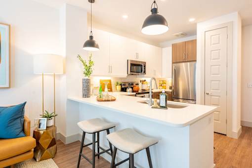 A kitchen with a white counter and a stainless steel refrigerator.
