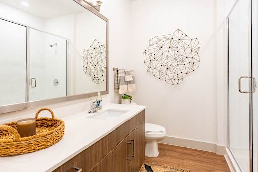 A bathroom with a white counter top and a wicker basket on it.
