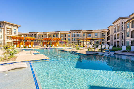 A large swimming pool in front of a resort.