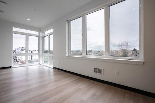 A room with a view of the city through large windows.