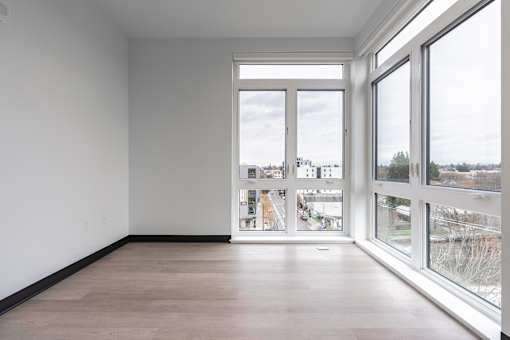 A room with a view of the city through large windows.
