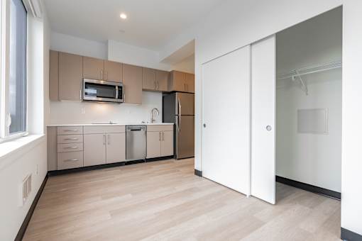 A kitchen with a microwave oven built into the cabinetry.