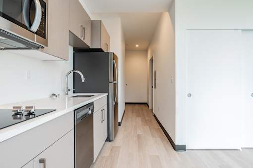 A modern kitchen with a black fridge and stove top oven.
