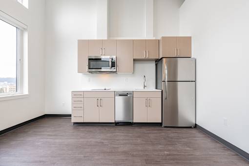 A kitchen with a microwave, dishwasher, and refrigerator.