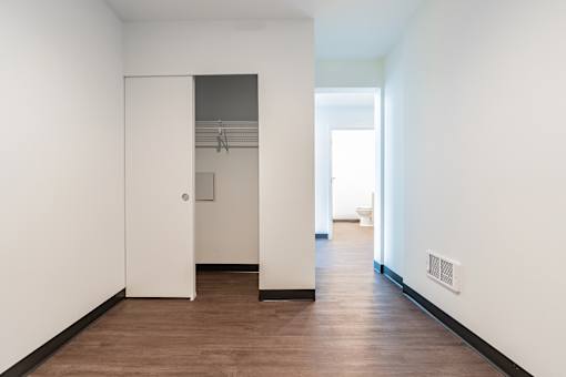 A hallway with a white door and a brown floor.