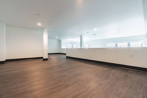 A large empty room with wooden floors and white walls.