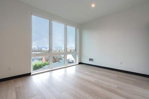 A large empty room with a view of the city through the windows.