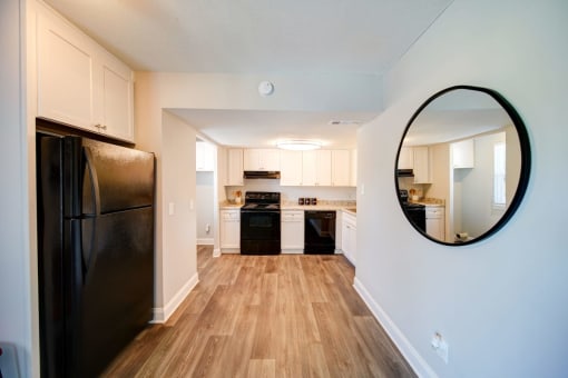 a kitchen with a black refrigerator freezer next to a stove top oven