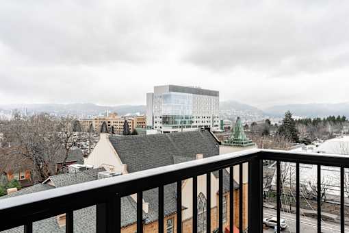 A balcony overlooks a cityscape with a large building in the distance.