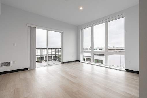 A spacious room with a view of the city through large windows.