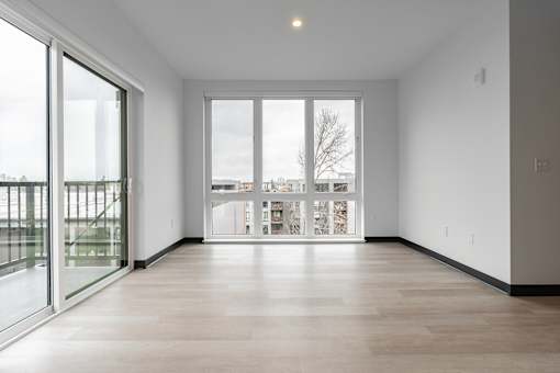 A large empty room with a view of the outside through the windows.