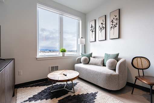 A living room with a couch, a coffee table, and a chair.