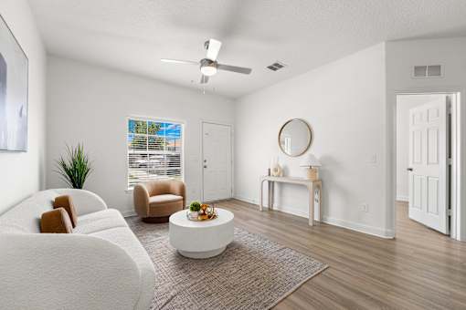 Pet-Friendly Townhomes in Kissimmee, FL – Estates at Lake Cecile - A living room with a white couch, a coffee table, and a ceiling fan.