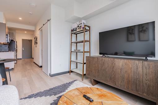 A modern living room with a wooden entertainment center and a flat screen TV.