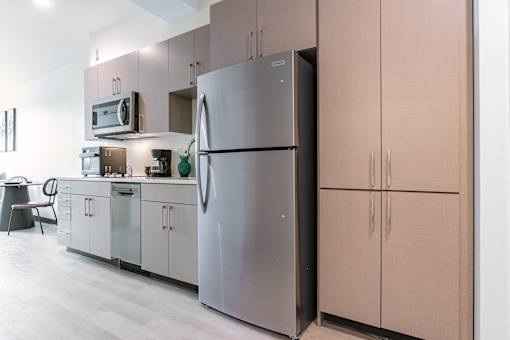 A modern kitchen with a refrigerator and cabinets.