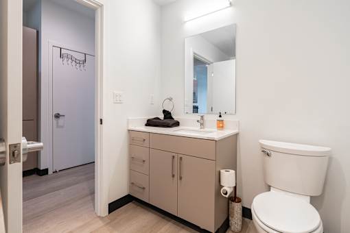 A bathroom with a toilet, sink, and mirror.