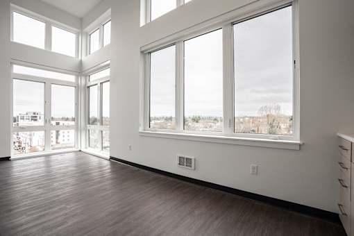 A room with a view of the city through large windows.