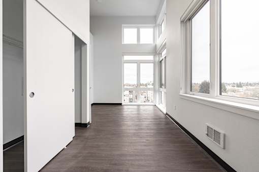A long hallway with white walls and wood floors.