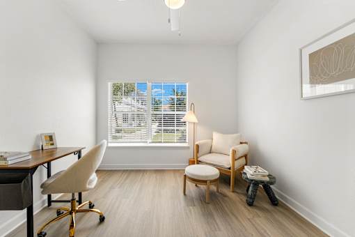 Kissimmee, FL Townhomes for Rent - Estates at Lake Cecile – A room with a desk, chair, and window with blinds.