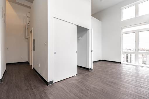 A white door is open in a room with wood flooring.