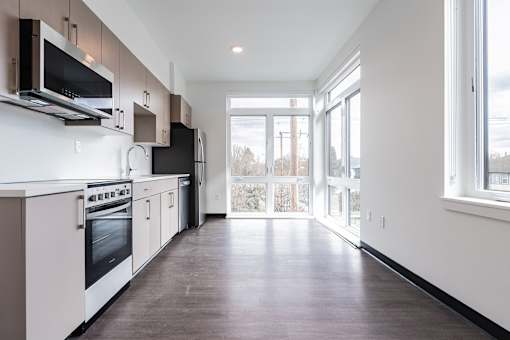 A kitchen with white cabinets and black appliances.