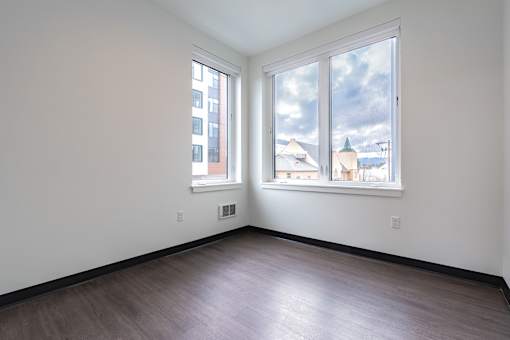 A room with a large window and a wooden floor.
