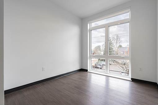 A room with a large window and wooden flooring.