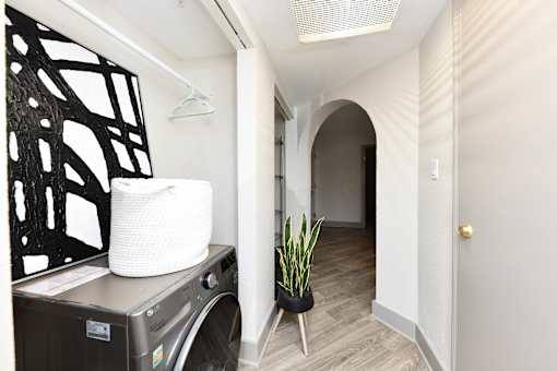 A laundry basket sits on a washing machine in a small room.