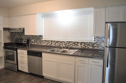 a kitchen with white cabinets and stainless steel appliances