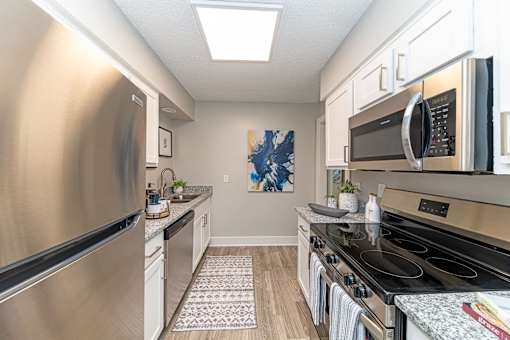 Hendersonville, TN Apartments – Reserve at Drakes Creek -A kitchen with a stainless steel refrigerator and a black stove top oven.