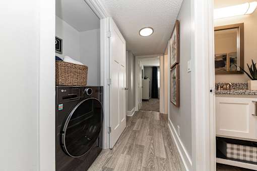 Hendersonville, TN Apartments – Reserve at Drakes Creek -A hallway with a washer and dryer in the doorway.
