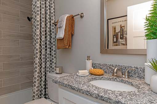 Pet-Friendly Apartments In Hendersonville, TN – Reserve at Drakes Creek-A bathroom with a grey granite countertop and a white sink.