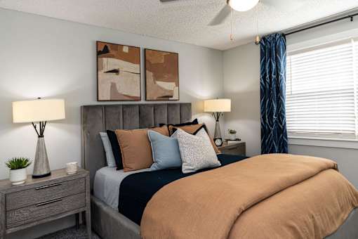 Hendersonville, TN Apartments – Reserve at Drakes Creek -A bedroom with a bed, nightstand, and two lamps.