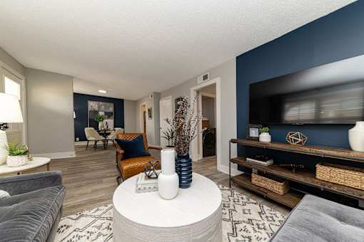 Pet-Friendly Apartments In Hendersonville, TN – Reserve at Drakes Creek-A living room with a grey sofa, a white coffee table, and a blue accent wall.