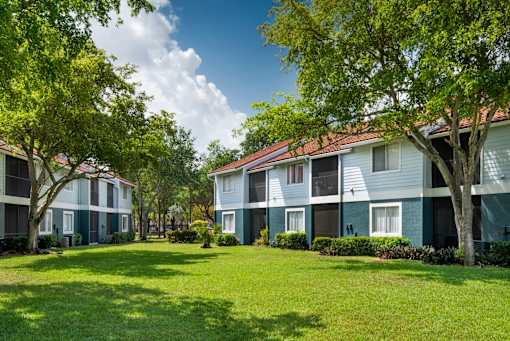 A grassy area in front of apartment buildings.