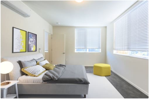 a bedroom with a bed and two windows