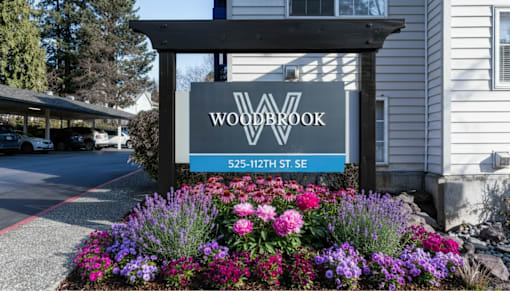 A sign for Woodbrook is displayed in front of a building.