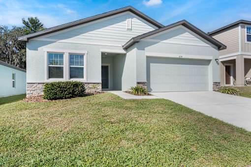 A two-story house with a garage and a driveway.