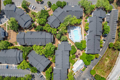 Flats on Maple Street A bird's eye view of a residential area with houses, a swimming pool, and a parking lot.