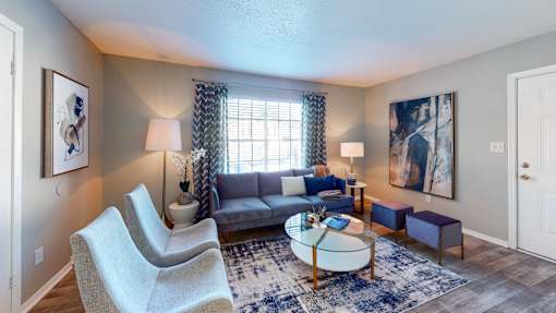 Living room at Broad on the Green in Augusta, GA, featuring a large window with natural light in a pet-friendly apartment community.