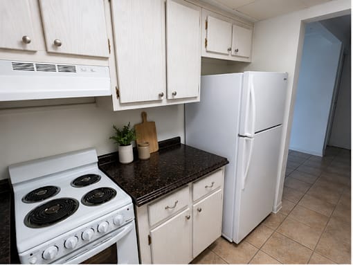 Functional kitchen at RTW Rentals in Fort Lauderdale featuring white appliances, ample cabinet storage, durable countertops, and easy-to-maintain finishes.