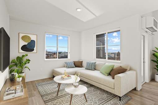 A living room with a white couch, a coffee table, and a painting on the wall.