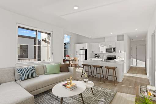 A modern living room with a grey sofa and a white coffee table.