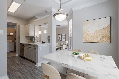 Pet-Friendly Apartments in Houston, TX – Gramercy Park – an open kitchen and dining room with a marble table and chairs